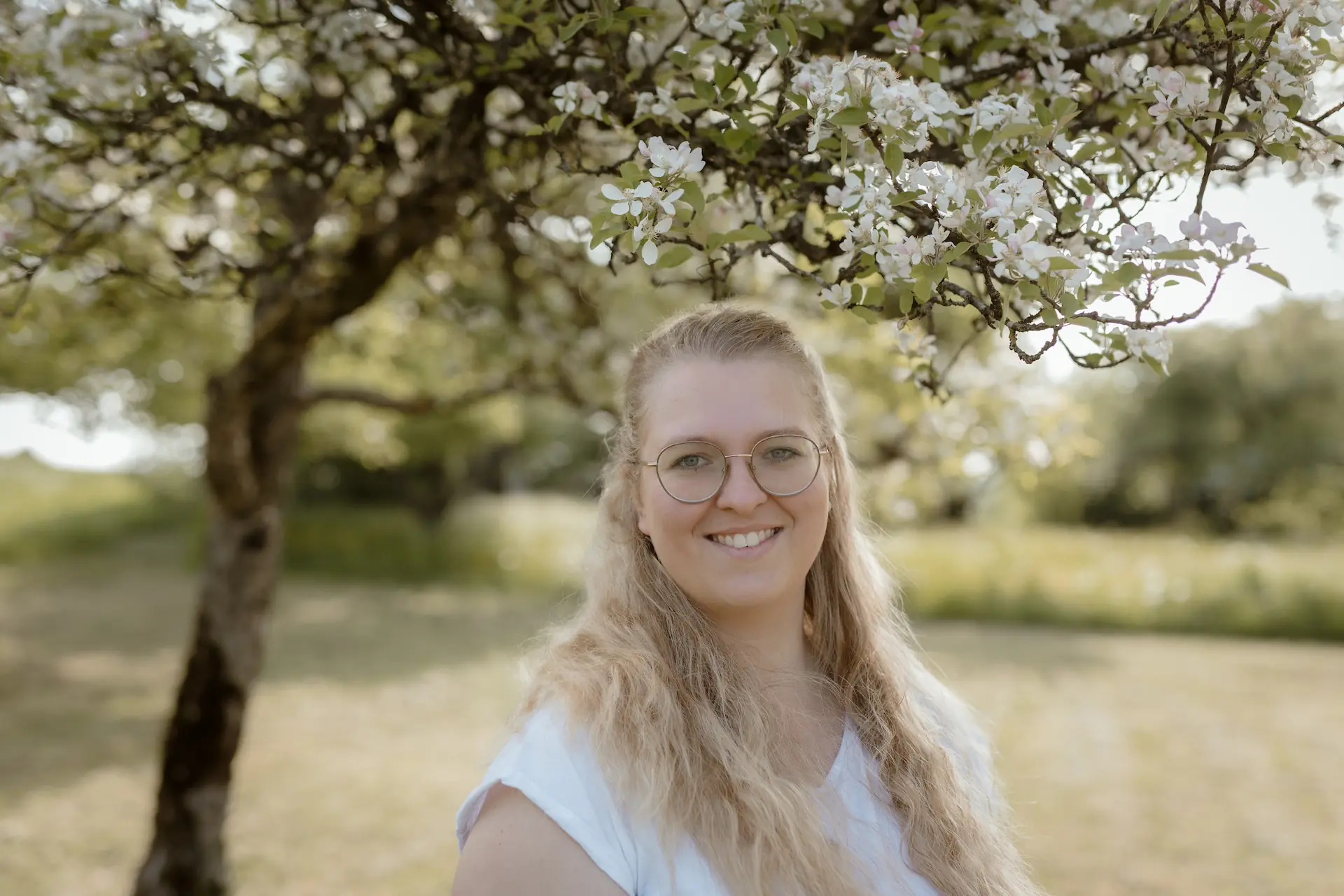 Blonde Frau mit Weißem Oberteil, auf einer Obstwiese in der Bodenseeregion